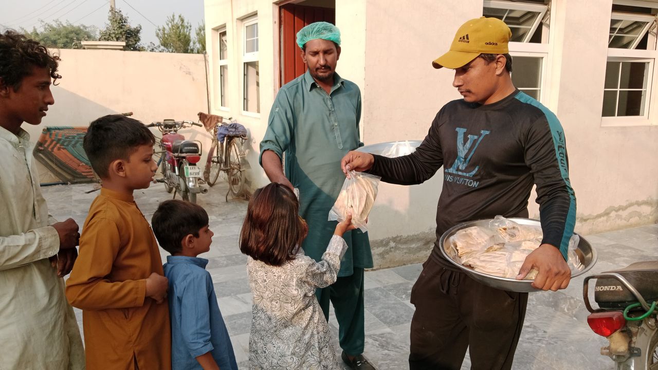 Volunteers distribute food packages to children in community charity effort.